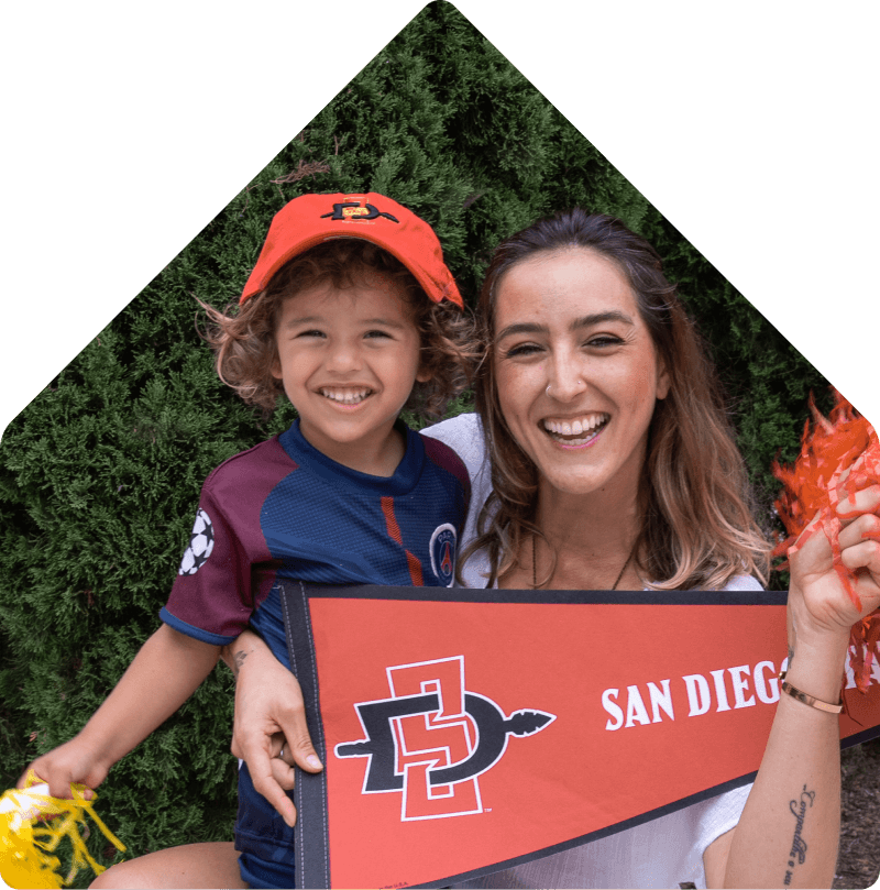 Mother holding son with a flag from San Diego State University.